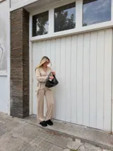 Pantalón de lanilla color negro, de corte recto y tiro alto, con diseño holgado y fluido.