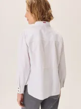 Camisa de corte femenino y sofisticado, con cuello redondo, manga larga y cierre frontal de botones. Confeccionada 100% en algodón.