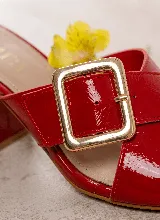 Sandalia de taco ancho color dorado, confeccionada en cuero vacuno, con diseño de tiras cruzadas y hebilla metálica decorativa.