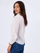 Camisa blanca de algodón con delicado diseño bordado en toda la prenda, cuello clásico, manga larga y cierre frontal abotonado.