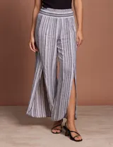 Pantalón de lino con rayas verticales grises y blancas, pretina ancha elastizada en punto smock, pierna ancha y ruedo con tajo.
