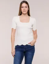Blusa de punto acanalado color blanco, con escote cuadrado, mangas cortas y terminaciones festonadas en mangas y ruedo.