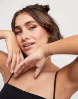 Pulsera de cadena fina con eslabones ovalados bañada en oro de 18k, con cierre de mosquetón y pequeña placa con logotipo colgante.