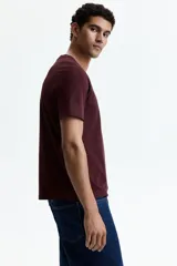 Remera de algodón liviano color bordó, con cuello redondo ribeteado y mangas cortas, de corte estándar.