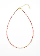 Gargantilla corta de acero quirúrgico hipoalergénico con mostacillas brillantes de colores y dije central dorado en forma de rombo.