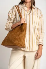 Camisa de corte oversize con estampado de rayas verticales en tonos verde, blanco y ocre. Presenta cuello clásico, cierre frontal con botones, bolsillo en el pecho y mangas largas con puños abotonados.