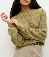 Suéter de punto con textura jaspeada, cuello redondo y mangas largas amplias con puños ajustados. Presenta un corte regular y diseño versátil.