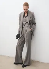 Blazer de corte recto y diseño estructurado, confeccionado en tejido mezcla de lana. Presenta cuello con solapas de muesca, cierre frontal de doble botonadura, bolsillos laterales con solapa y bolsillo de ribete en el pecho. Incluye forro interior y mangas largas con puños abotonados.