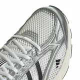 Championes Adidas Spiritain 2000 de diseño running retro, color blanco con detalles plateados y las clásicas tres tiras en negro. Incorpora tecnología adiprene+ en la suela para mayor amortiguación.
