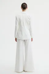 Pantalón de vestir color blanco, de corte sastrero con silueta amplia y caída fluida.