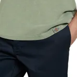 Remera verde claro de manga corta con pequeño estampado circular en el pecho, de corte holgado.