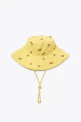 Gorro tipo bucket amarillo con bordado de flores y cordón ajustable.