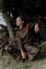 Pantalón de corte recto con estampado a cuadros en tonos marrones y rosados. Presenta una pretina elástica para mayor comodidad y está confeccionado en una tela acanalada con caída suave.