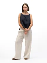 Musculosa de lino con cuello redondo, diseño holgado y laterales abiertos unidos por tres tiras horizontales.