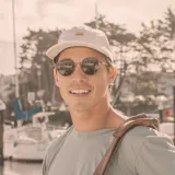 Lentes de sol Sunski Baia con montura redonda color cobre y lentes polarizados color verde oscuro.