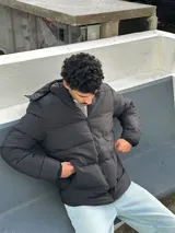 Campera puffer negra con capucha forrada en corderito.