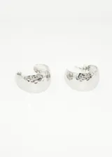 Aros plateados tipo argolla con textura irregular.