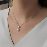 Conjunto de collar y aros en plata 925 con perlas de río y circonias. El collar tiene una cadena de 42cm y dos perlas colgantes de 6,5mm y 8,5mm.