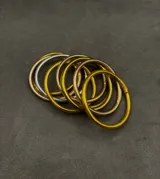 Set de pulseras circulares flexibles de estilo oriental, con acabado brillante en tonos dorados y plateados, rellenas de lámina metálica.