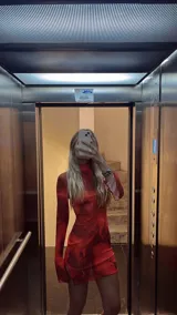 Minivestido rojo de microtul elastizado con estampado abstracto en tonos oscuros. Diseño ajustado con cuello alto y mangas largas.