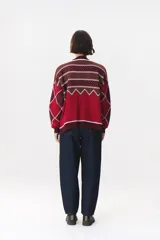 Buzo de tejido de punto con diseño geométrico y combinación de colores en contraste. Presenta cuello redondo, mangas largas y corte oversized.