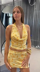 Minifalda amarilla con estampado floral dorado y cintura baja.