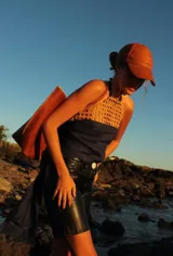 Bermuda de cuero color marrón oscuro con efecto desgastado, tiro medio, cierre frontal con botón y bolsillos.