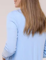 Cárdigan liviano blanco de punto acanalado, confeccionado en viscosa y elastano, con diseño de frente abierto, mangas largas entalladas y silueta fluida.