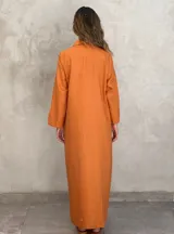 Vestido camisero largo color verde lima, con cuello camisero, mangas largas con puños abotonados, cierre frontal con botones y lazo anudado en la cintura.