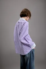 Camisa de manga larga con cuello solapa y puños en contraste color blanco. Presenta un diseño de rayas verticales en color lila y blanco, con cierre frontal de botones.