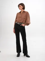 Pantalon de pana color marrón, de corte ajustado con costuras verticales frontales y tajos en el ruedo.