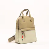 Mochila color beige con textura símil cuero en la parte superior y textura tejida en la parte inferior. Tiene doble asa de mano, correas ajustables para la espalda, cierre superior y bolsillo frontal con cierre y adorno de cuentas de colores.