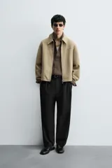 Cazadora regular fit de piel con acabado ante napado, color beige. Sin forro interior, cuello solapa, manga larga, bolsillos de vivo en cadera y cierre frontal con cremallera.