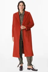 Tapado largo de paño en color terracota, con solapas clásicas, cierre frontal oculto y bolsillos laterales. Presenta un corte recto y estructurado, ideal para un estilo sofisticado y urbano.