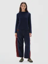 Jean barrel colorblock de denim azul marino y pana bordó, con pierna ancha que se estrecha hacia el tobillo. Presenta cintura ajustada y corte relajado en cadera y muslo.