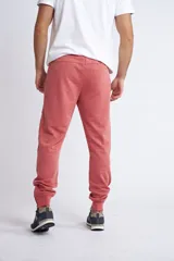 Jogging de corte slim, color coral, con bolsillos laterales con cierre, puños con cierre y cordón ajustable en la cintura.