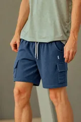 Bermuda cargo de tejido waffle en color azul piedra, con cintura elástica con cordón ajustable de color blanco y bolsillos laterales con solapa.