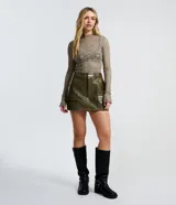 Short pollera corto de material sintético PU color verde militar, con bolsillos delanteros grandes con solapas, trabillas en la cintura y cierre frontal por cremallera.