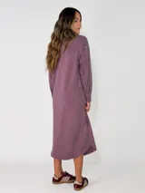 Vestido camisero midi de corte recto y holgado, con cierre frontal de botones, cuello camisero, mangas largas con puños abotonados y bolsillos frontales superiores con solapa.