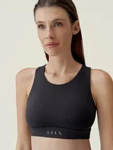 Top deportivo de sujeción media-alta, con diseño de espalda cruzada y tecnología láser. Presenta un corte de cuello redondo y banda elástica inferior con logo estampado.