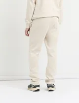 Pantalón jogging de corte recto, confeccionado en tejido circular con cintura elástica y cordón ajustable al tono. Presenta bolsillos laterales tipo parche.