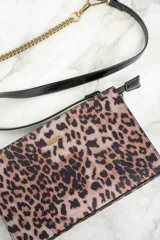 Cartera tipo sobre con estampado animal print, correa de cuero sintético negra y cadena dorada.