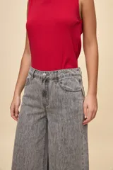 Jean wide leg de tiro alto color celeste, con calce amplio y pierna ancha, diseño de cinco bolsillos y cierre frontal con botón y cremallera.