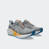 Championes de running Asics modelo Novablast 5, color gris con detalles en blanco, naranja y azul. Presentan una mediasuela con tecnología FF BLAST MAX para mayor amortiguación y retorno de energía, y una capellada de malla jacquard transpirable.