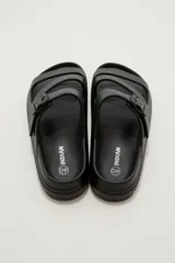 Sandalias de goma color negro con diseño de tres tiras cruzadas y hebilla lateral ajustable.