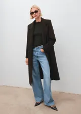 Top de crepé con textura, color verde oscuro, diseño entallado, cuello festoneado y manga larga.