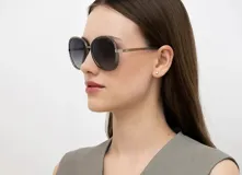 Lentes de sol INVU con montura redonda de metal plateado y doble aro en color oliva. Lentes polarizadas con degradé de gris a transparente.