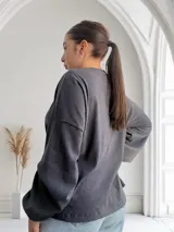 Remera gris topo de tejido acanalado, corte recto y mangas largas.