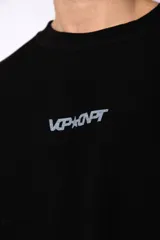 Buzo de cuello redondo confeccionado en tejido rústico con bordes al corte y costuras expuestas. Presenta un diseño boxy con estampado frontal y es reversible, permitiendo su uso por ambos lados.