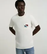 Remera de algodón color crudo, con cuello redondo y manga corta. Presenta un bolsillo en el pecho con estampa náutica y lettering "M.R.F.".